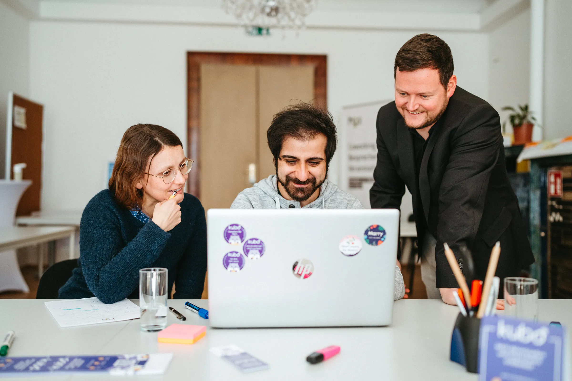 Das Team von itell.solutions bespricht gemeinsam mit einer Kundin eine Lösung am Laptop
